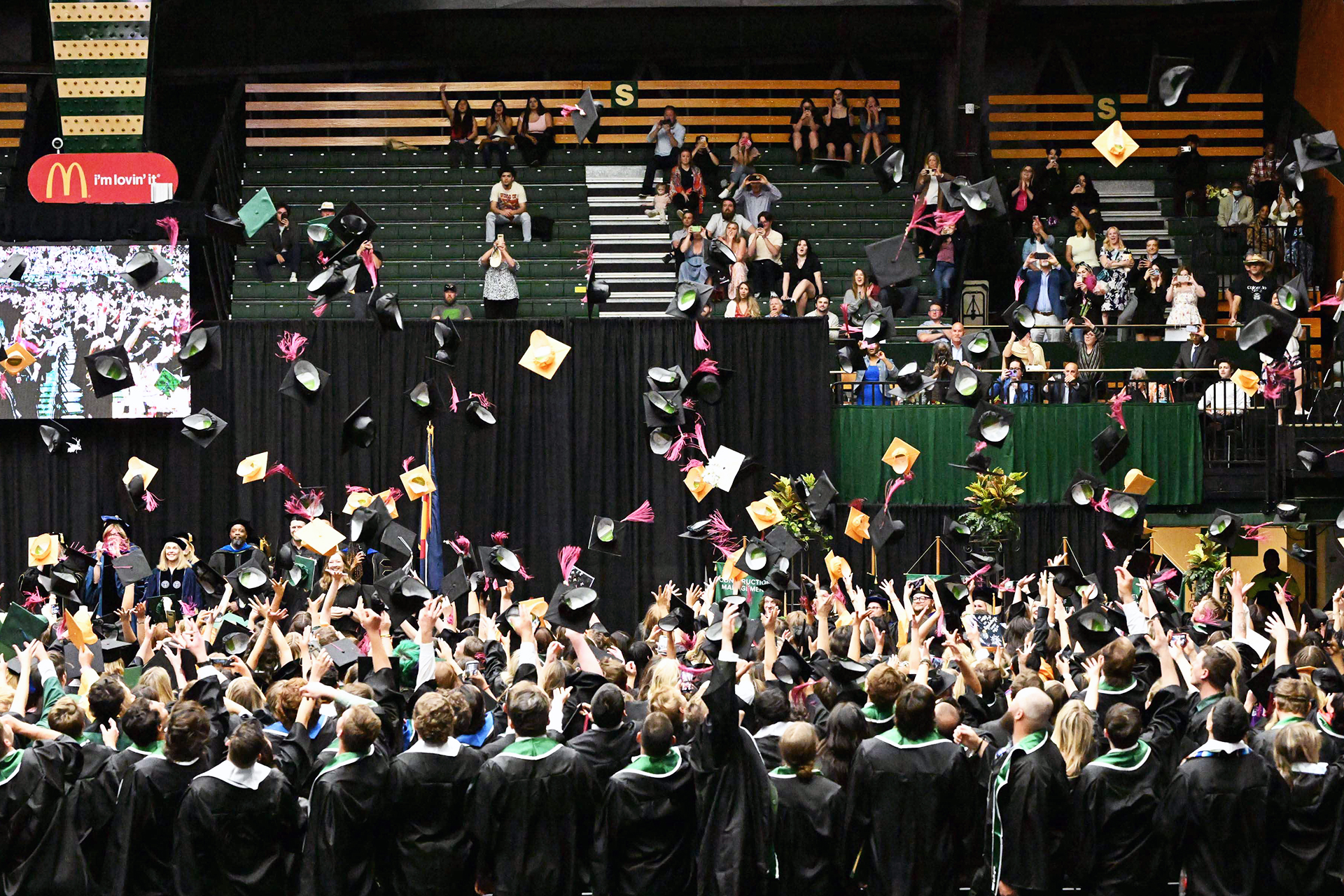 CSU graduates throw their mortar boards into the air during a 2024 commencement.