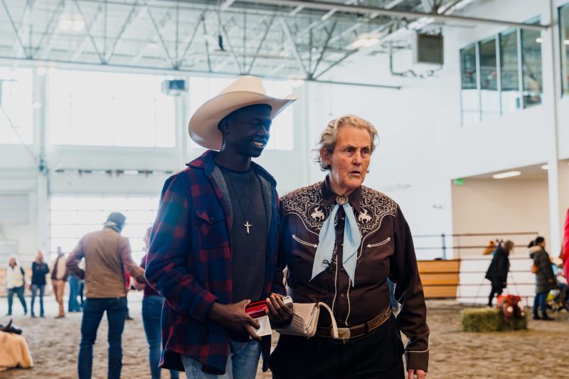 A man takes a photo with Temple Grandin at the Exceptional Rodeo