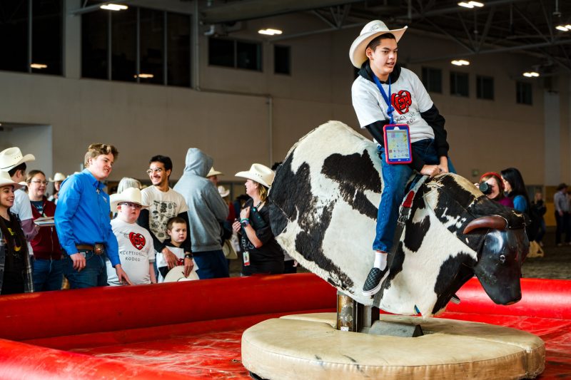 A kid rides a mechanical bull at the Exceptional Rodeo