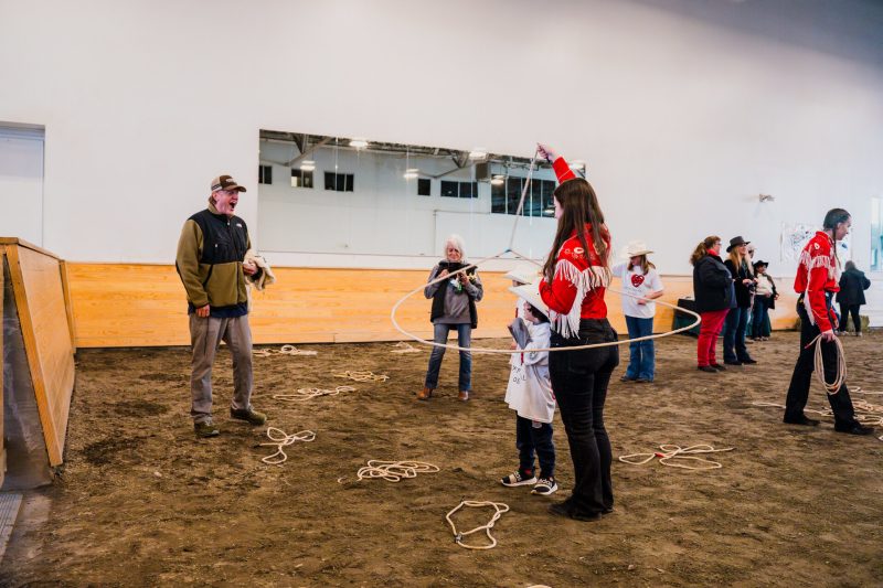 An FFA member teaches a kid some rope skills at the Exceptional Rodeo
