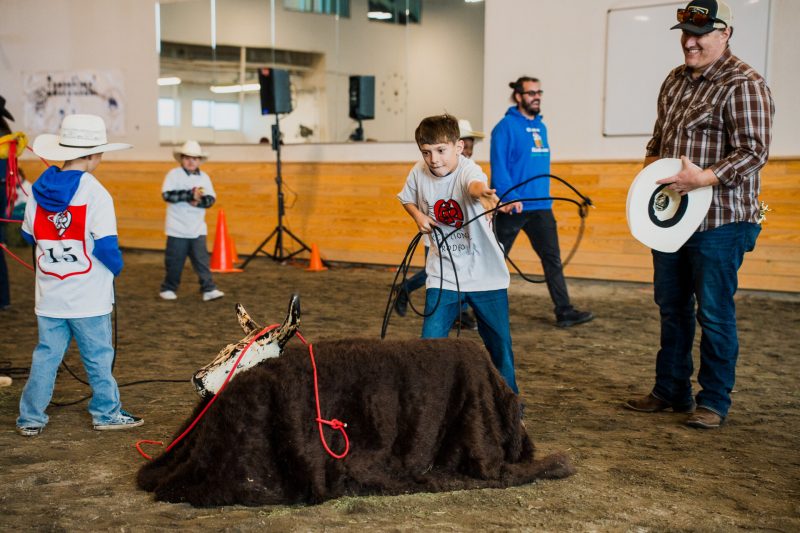 Child wrangles a mock cow at the Exceptional Rodeo